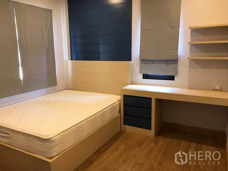Detached House for rent in Bang Phli, Samut Prakan - Cozy bedroom with built-in desk and shelves, single bed and blue feature wall.