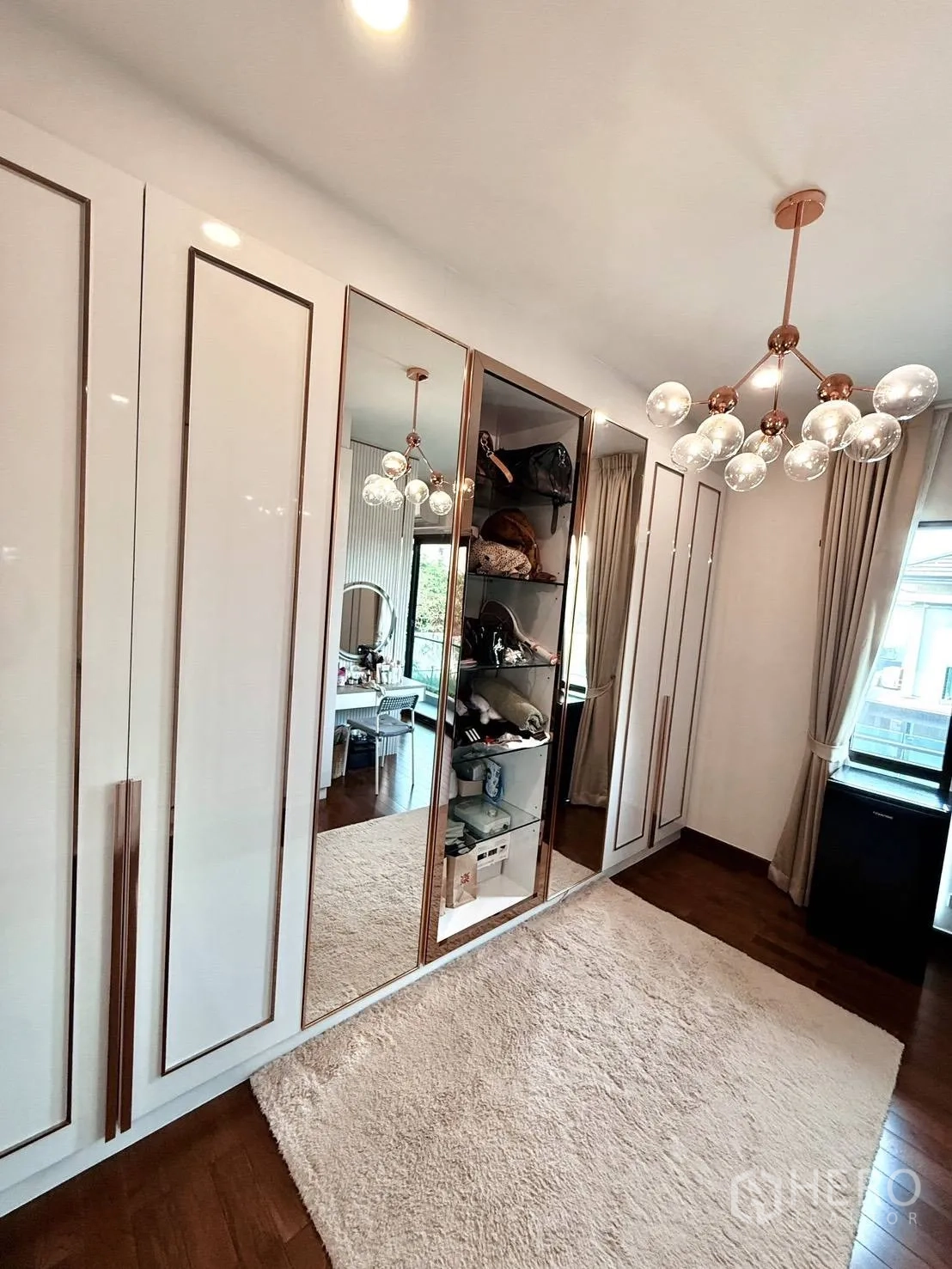 Detached House for rent in Wang Thonglang, Bangkok - Walk-in closet with mirrored wardrobes and window bringing in light.