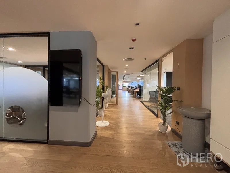 办公室 for rent in Bang Rak, Bangkok - 走廊摆放绿植，玻璃隔断通向办公室与会议室。