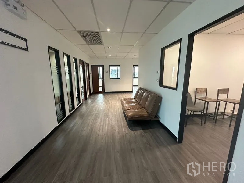 办公空间 出租在Khlong Toei, Bangkok - 走廊等候区配棕色沙发，旁边为会议室