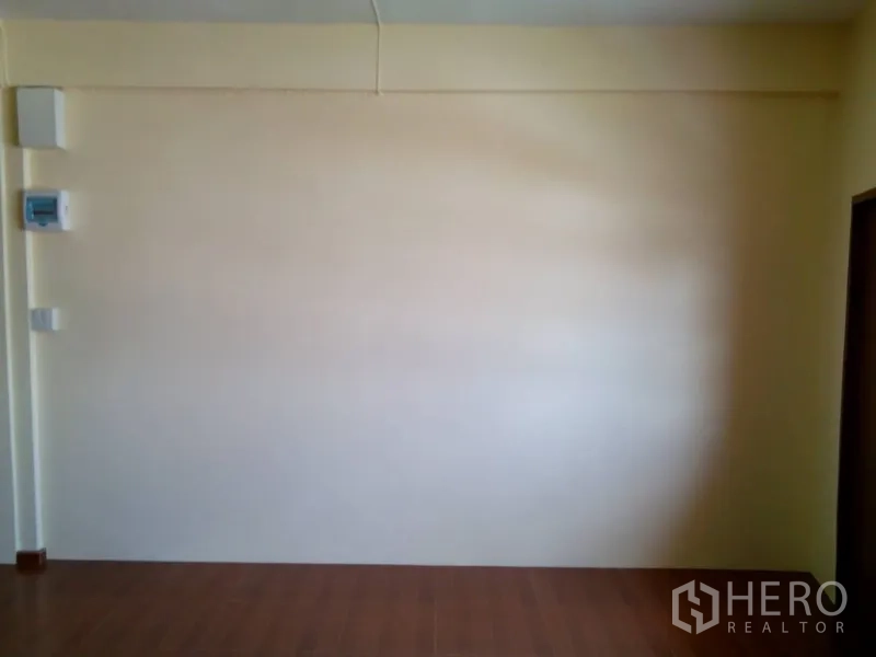 อาคารพาณิชย์ ให้เช่าในPhra Khanong, Bangkok - ผนังภายในสีครีมพร้อมตู้ไฟและสวิตช์