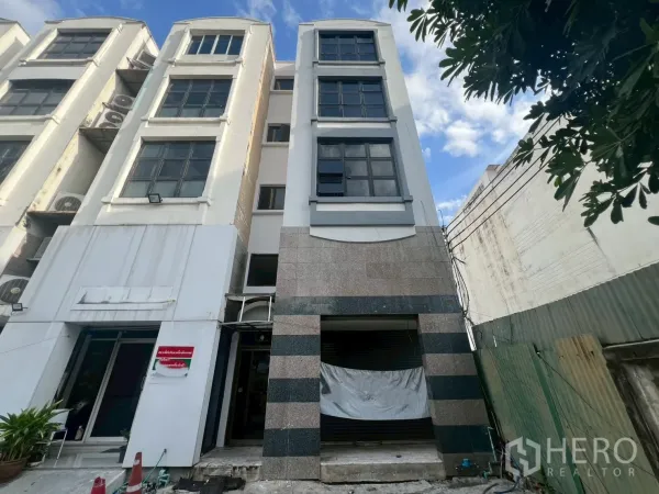 店屋 出租在Phra Khanong, Bangkok - 四层店屋外立面，宽窗与卷闸门入口。