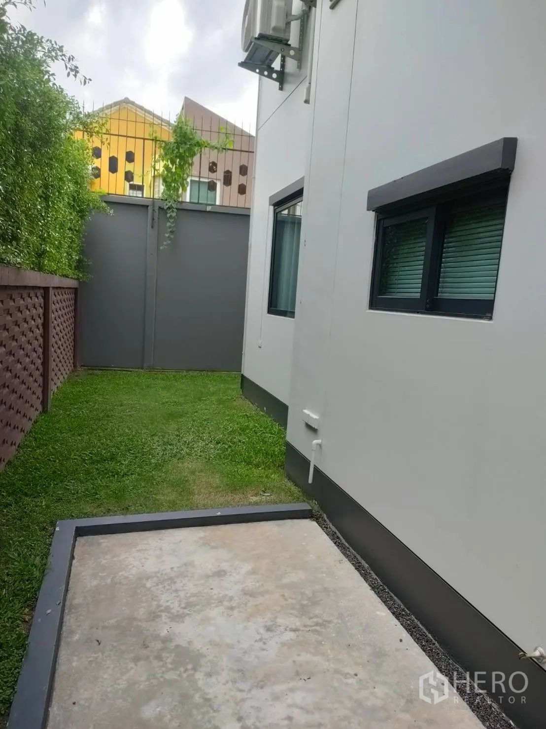 บ้าน ให้เช่าหรือขายในLam Luk Ka, Pathum Thani - อีกมุมของข้างบ้าน พื้นคอนกรีต สนามหญ้า และรั้วส่วนตัว