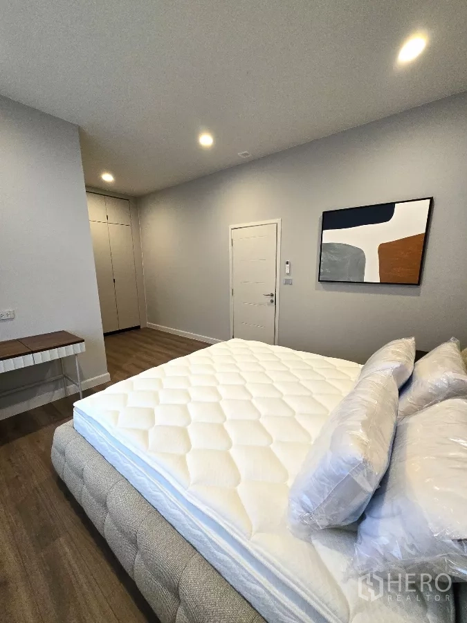 Detached House for rent in Bang Phli, Samut Prakan - Third bedroom with bed, wall art and ample closet storage.