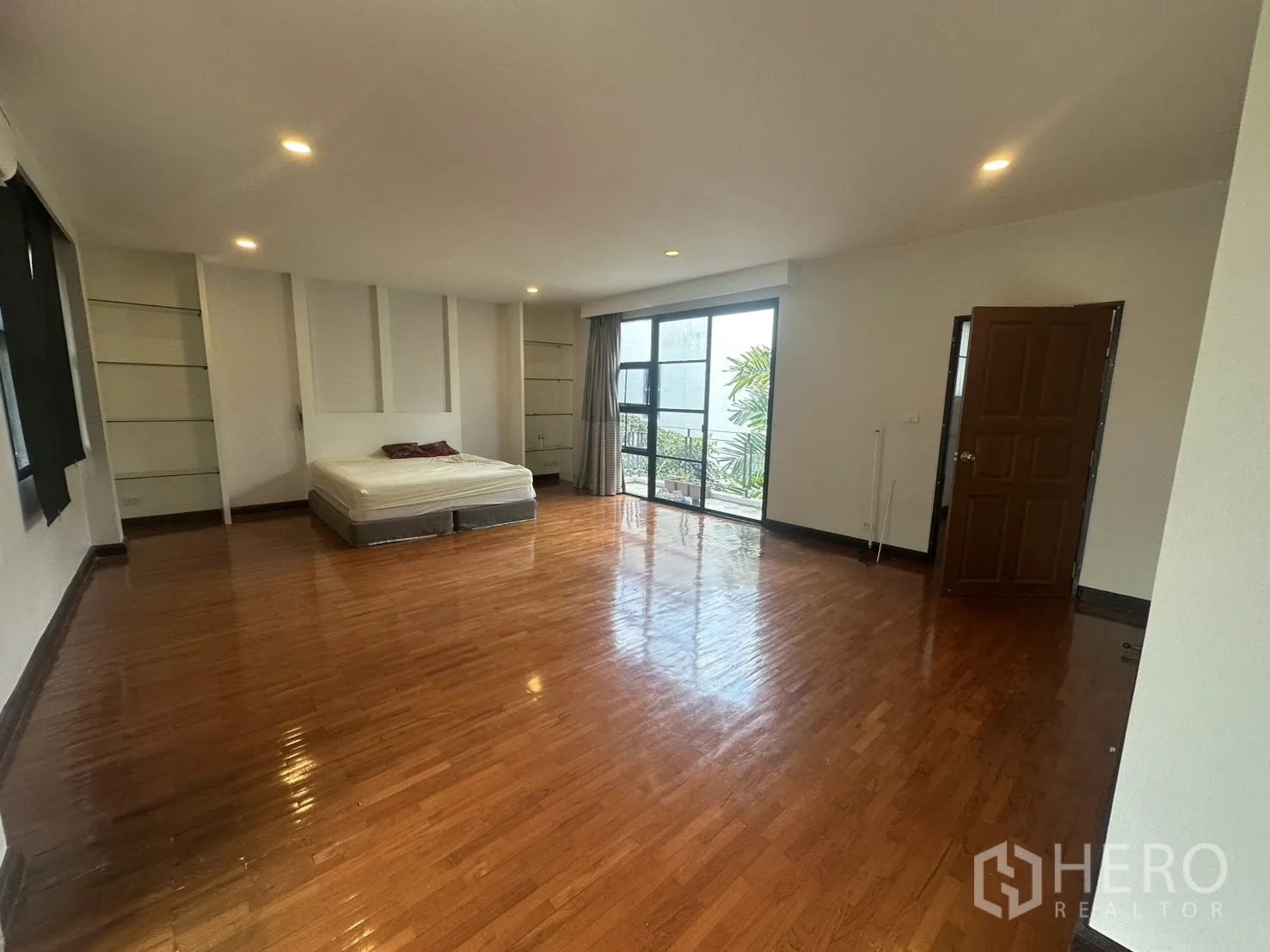 独栋房屋 for rent in Watthana, Bangkok - 卧室配阳台推拉门、木地板与筒灯