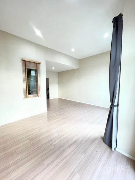 ทาวน์เฮาส์ ขายในBang Kapi, Bangkok - ห้องโล่งพื้นไม้ หน้าต่างพร้อมมู่ลี่และผ้าม่านสูง