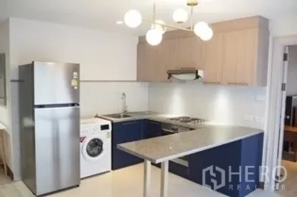 Condominium for rent in Pathum Wan, Bangkok - Modern kitchen with breakfast counter, stove, sink, fridge and washer.