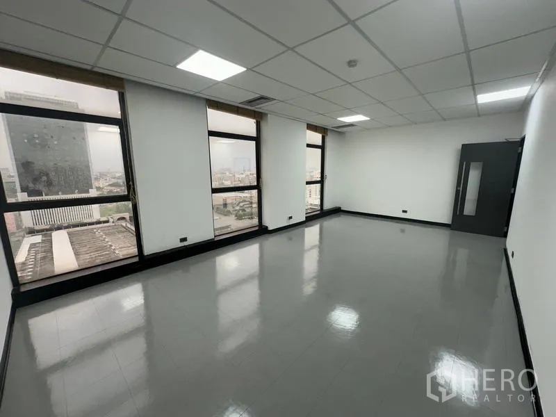 Office Space for rent - Spacious open-plan office with large windows and city skyline views bringing natural light.