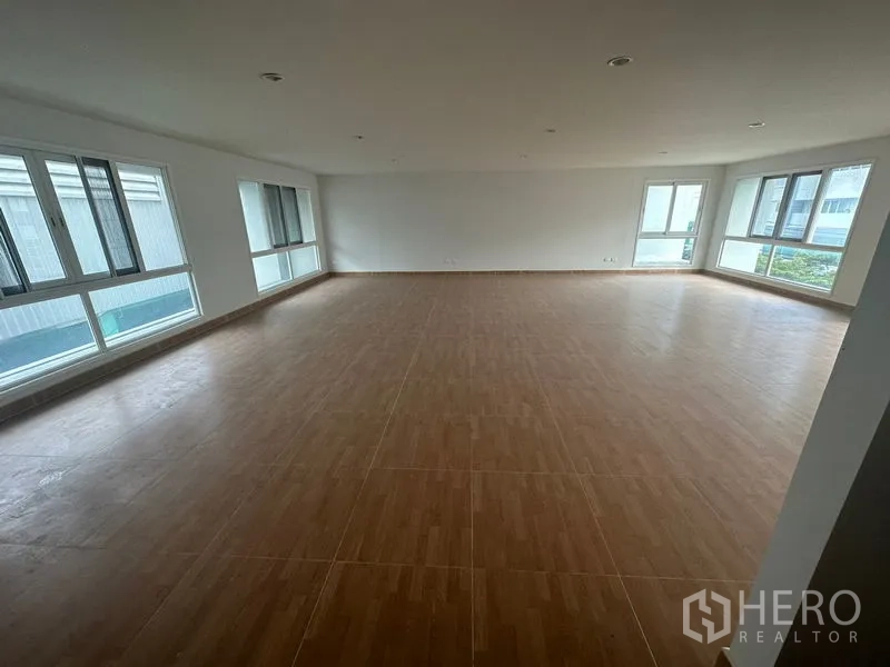 Home Office for rent in Bang Phli, Samut Prakan - Bright corner workspace with wood-look flooring and wraparound windows.