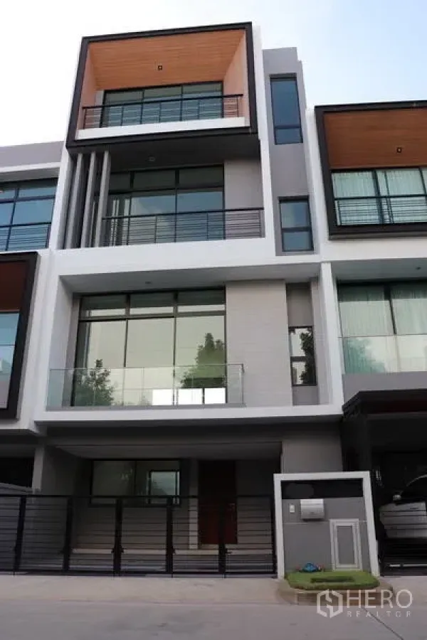 Townhouse for sale in Saphan Sung, Bangkok - Modern three-storey townhouse facade with balconies and large glass windows in Saphan Sung, Bangkok.