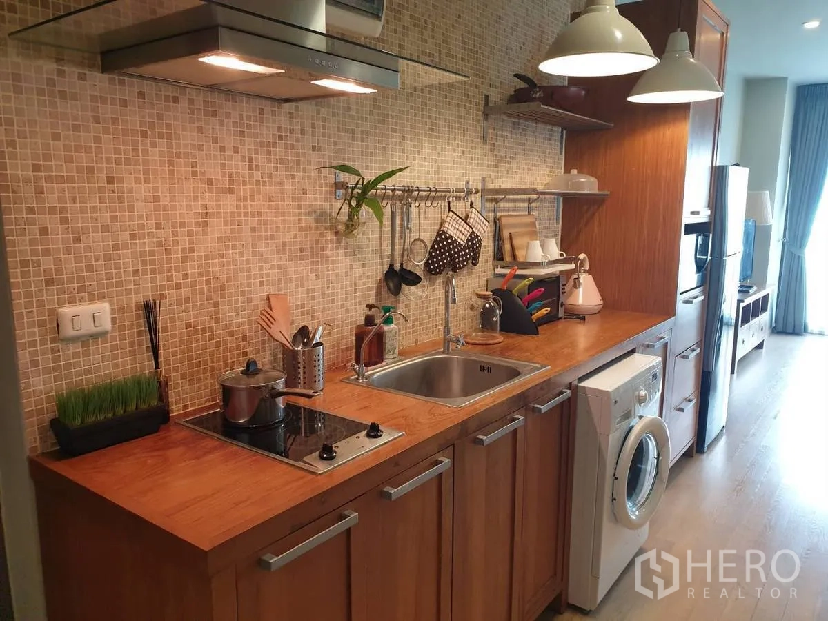 คอนโด ให้เช่าหรือขายในBangkok - ครัวแบบแกลลีย์สมัยใหม่ ผนังโมเสก เตา ซิงก์ และเครื่องซักผ้า