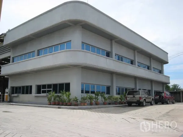 工厂 出租在Lat Lum Kaeo, Pathum Thani - 两层办公楼近景，设停车位与盆栽