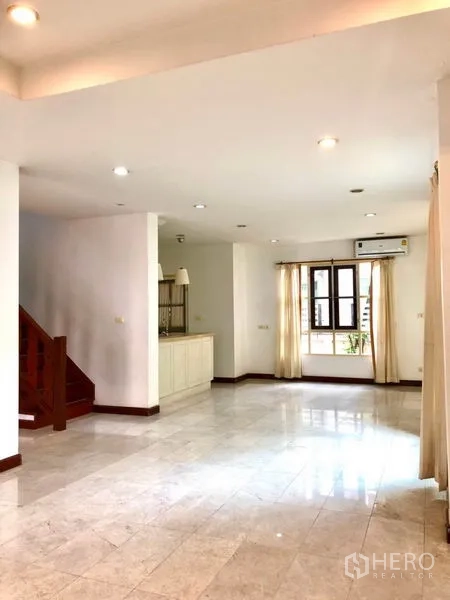 Detached House for rent in Saphan Sung, Bangkok - Spacious open-plan living and dining area with tiled floors, recessed lights and a staircase.