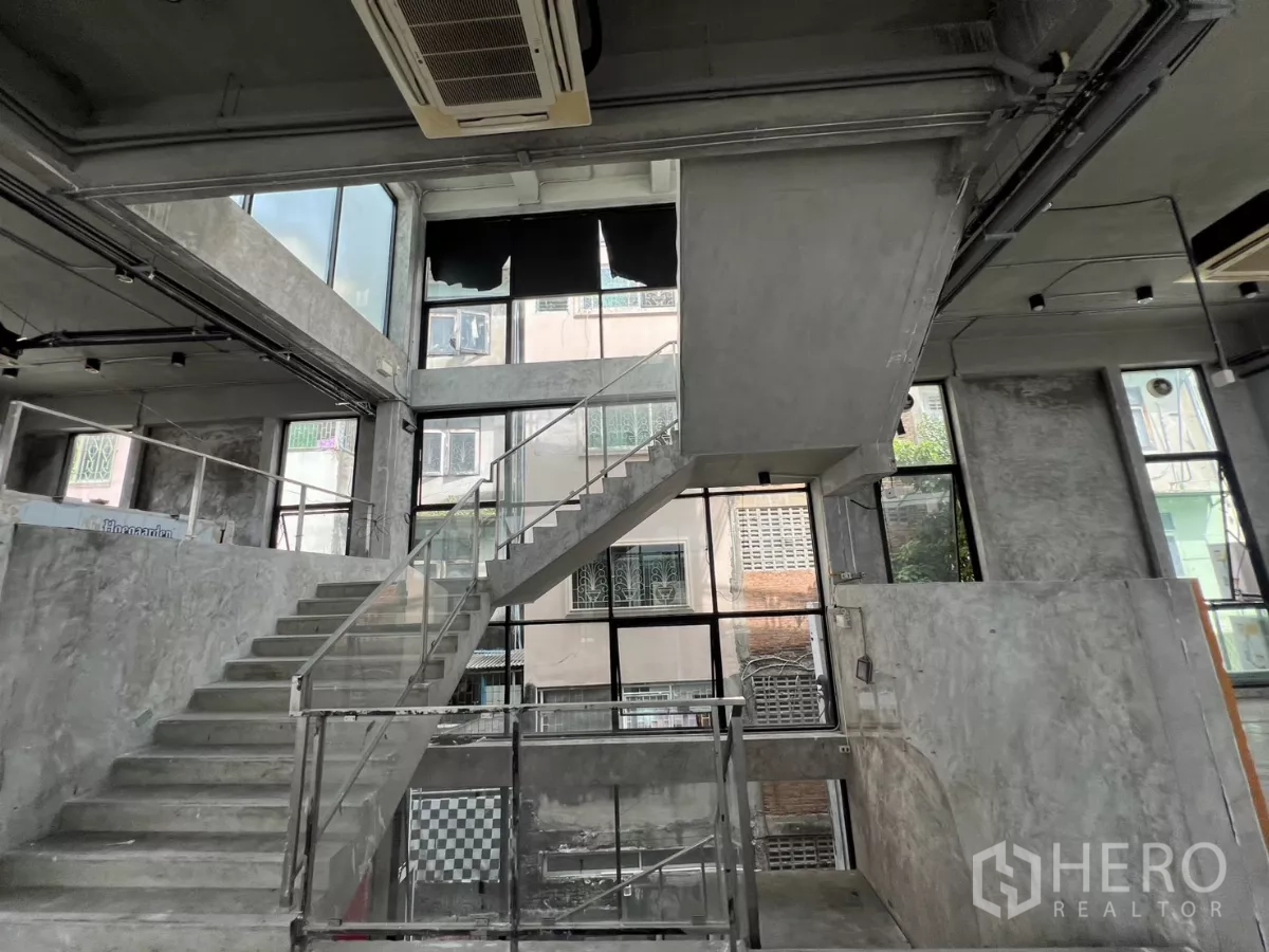 独立商业地产 出租在Din Daeng, Bangkok - 室内楼梯细节，玻璃栏杆与高窗。