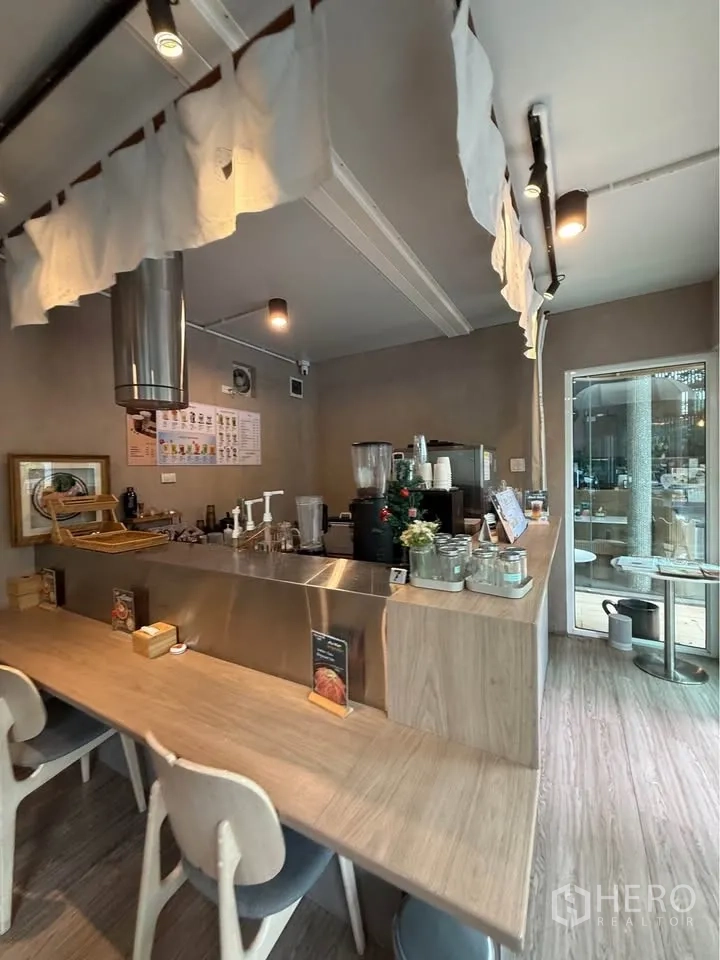Retail Space for rent in Watthana, Bangkok - Bar-style counter with stools and equipment in a warm-toned interior.