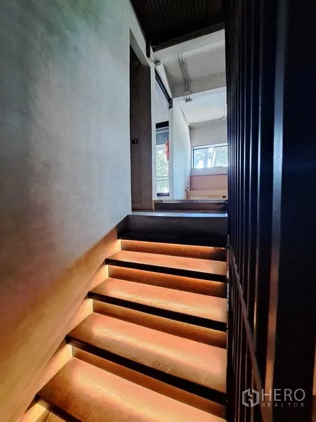 零售空间 出租在Watthana, Bangkok - 带LED灯的楼梯通往夹层，室内为混凝土墙面并有采光窗。