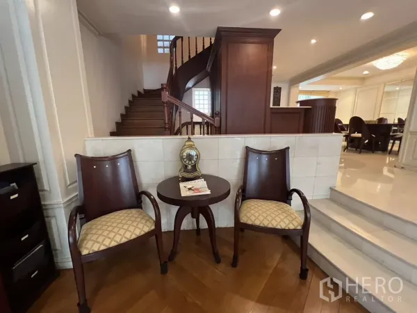 ทาวน์เฮาส์ ขายในWatthana, Bangkok - โถงบันไดไม้ พร้อมเก้าอี้นั่งสองตัวและไฟดาวน์ไลต์