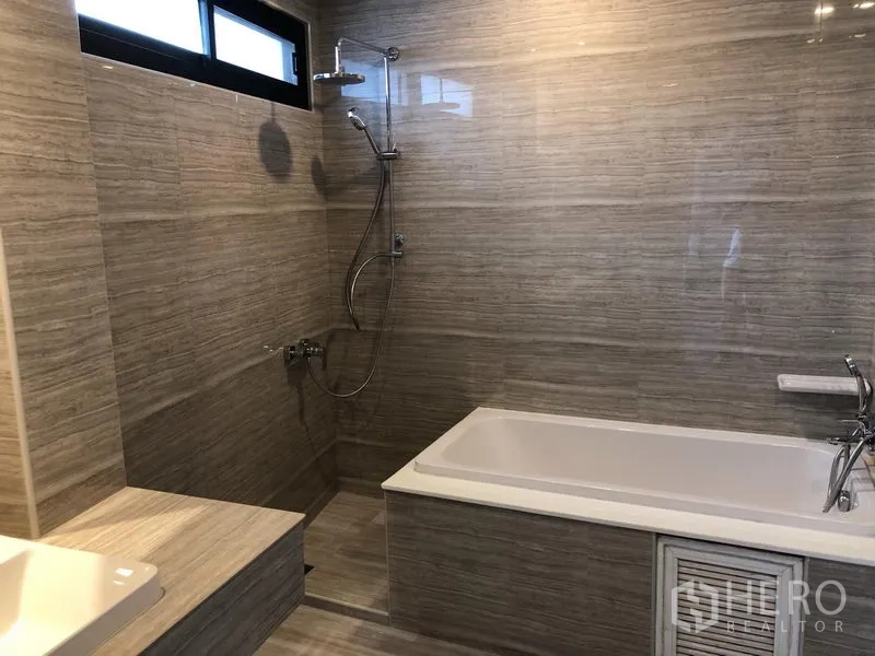 คอนโด ให้เช่าในKhlong Toei, Bangkok - ห้องน้ำสไตล์โมเดิร์นมีอ่างอาบน้ำ ฝักบัวแยก และผนังลายหินสีเบจ