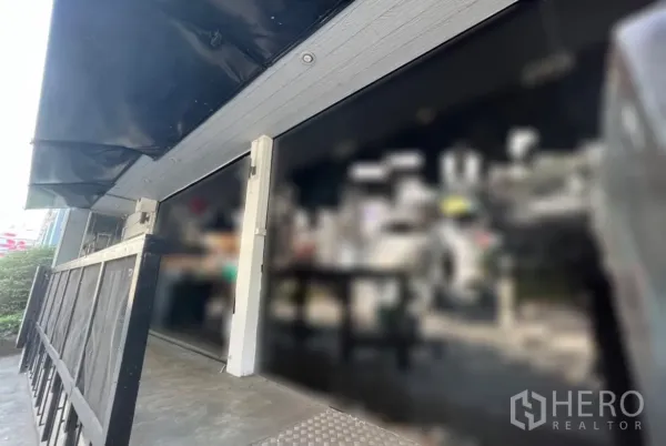 พื้นที่ขายปลีก ให้เช่าในWatthana, Bangkok - ด้านหน้าร้านกระจกพร้อมกันสาดสีดำและทางลาดทางเข้า