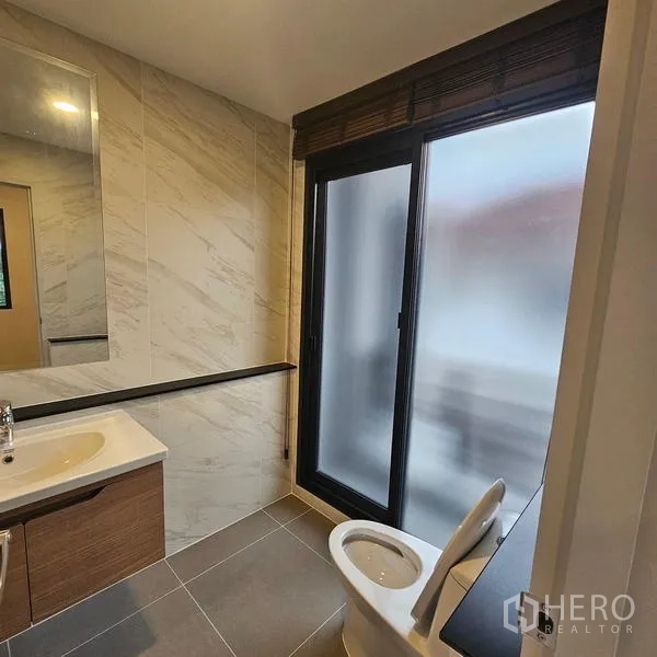 บ้าน ให้เช่าในSaphan Sung, Bangkok - ห้องน้ำพร้อมอ่างล้างหน้า โถสุขภัณฑ์ และประตูกระจกฝ้า รับแสงและระบายอากาศ.