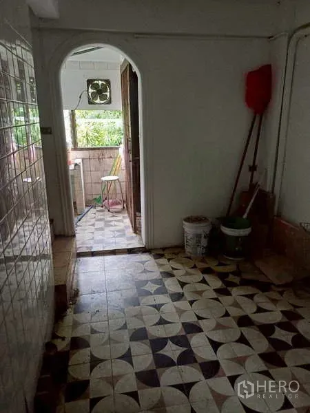 Shophouse for rent in Pom Prap Sattru Phai, Bangkok - Rear corridor with vintage patterned tiles leading to a small balcony.