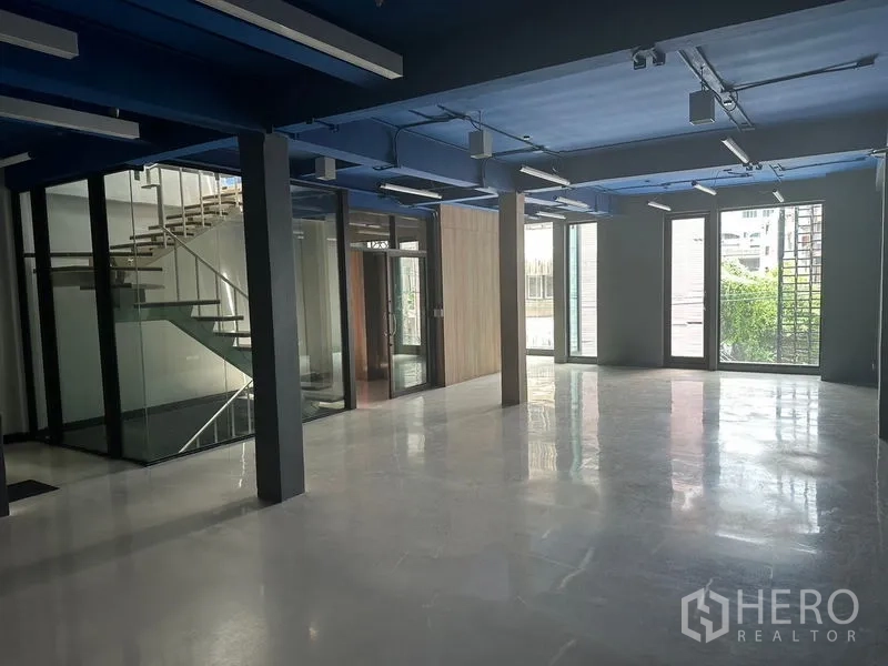 办公空间 出租在Watthana, Bangkok - 明亮的办公室，落地窗、玻璃楼梯间与光滑地面。