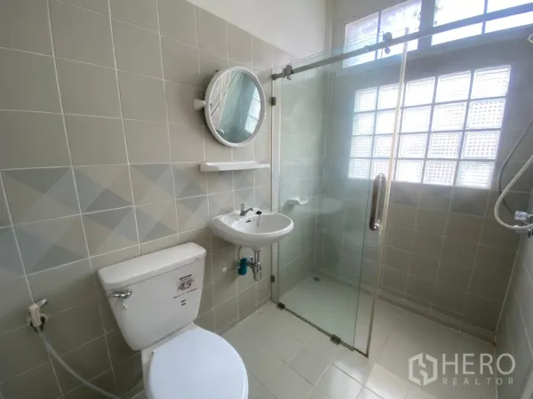 联排别墅 出租在Watthana, Bangkok - 明亮浴室，玻璃淋浴房、马桶和洗手盆，带玻璃砖窗