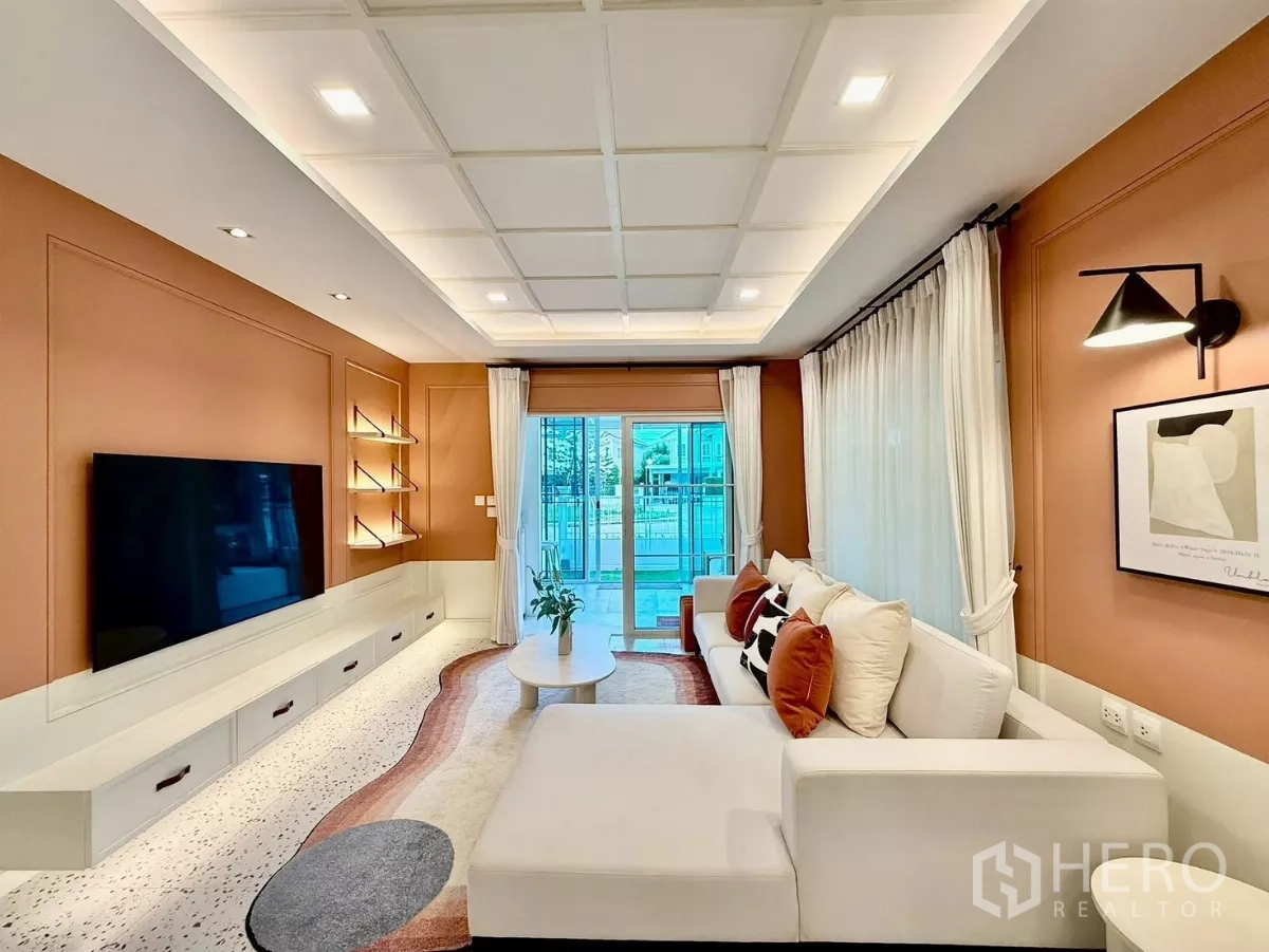 Detached House for rent in Bang Phli, Samut Prakan - Living room reverse angle showing TV feature wall and sheer curtains.