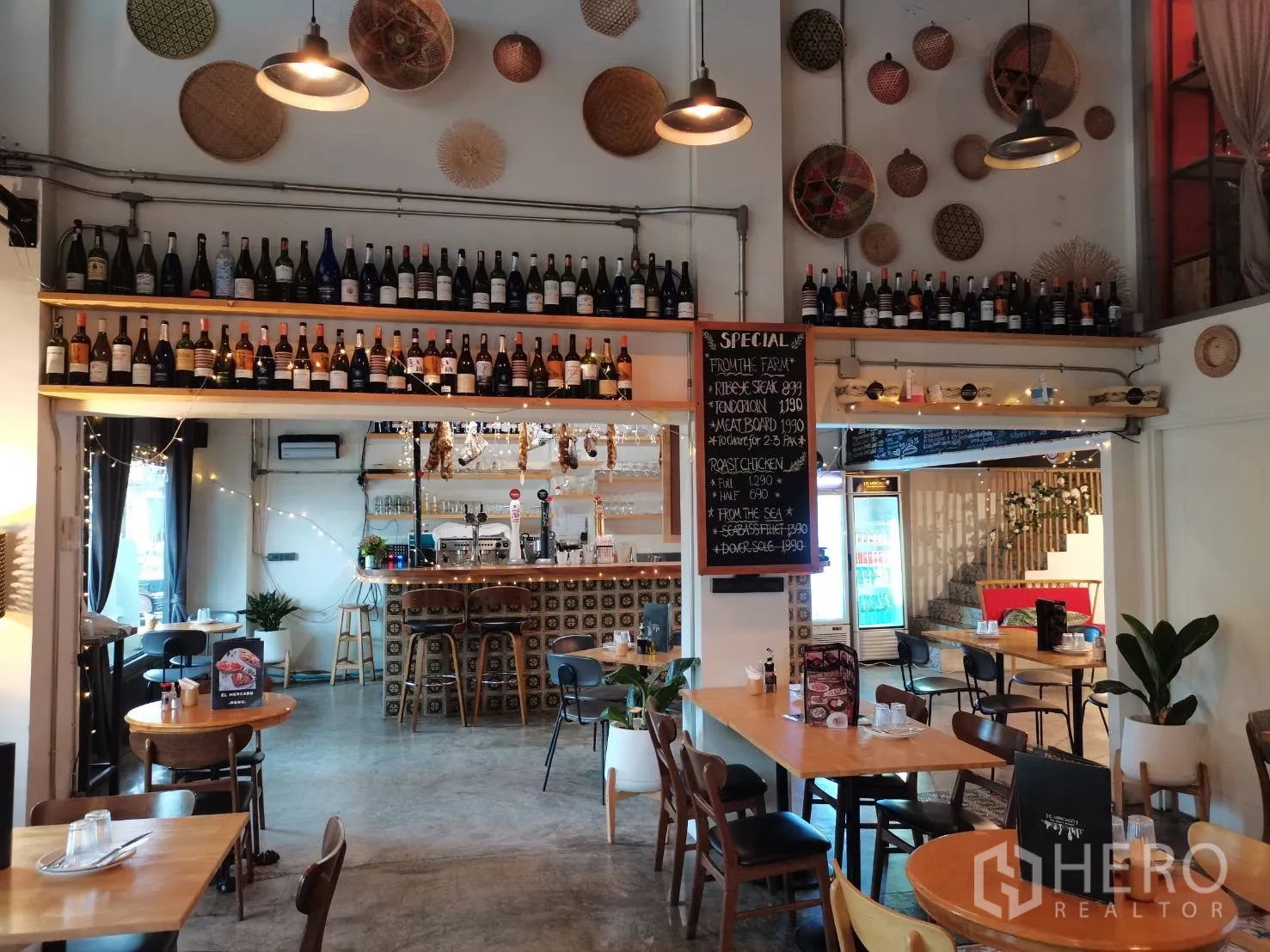 零售空间 出租在Watthana, Bangkok - 餐厅大厅面向吧台，墙上酒架与特价黑板。