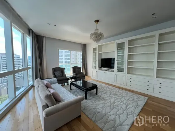 คอนโด ให้เช่าในKhlong Toei, Bangkok - โซนนั่งเล่นกว้าง พร้อมตู้เก็บของเต็มผนัง พรมผืนใหญ่ และกระจกมุมพาโนรามา