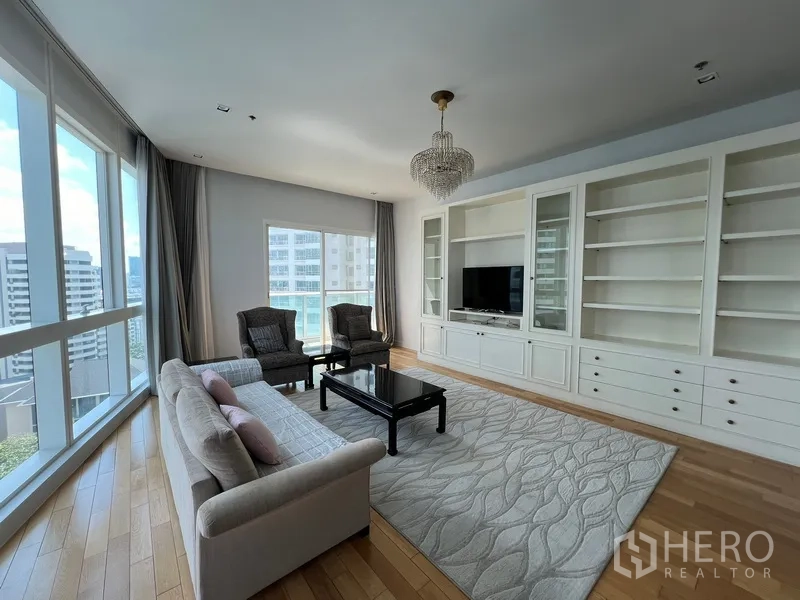 คอนโด ให้เช่าในKhlong Toei, Bangkok - โซนนั่งเล่นกว้าง พร้อมตู้เก็บของเต็มผนัง พรมผืนใหญ่ และกระจกมุมพาโนรามา