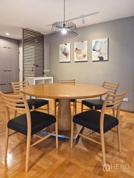Condominium for rent in Yan Nawa, Bangkok - Dining area with round wooden table, four chairs and a pendant light.