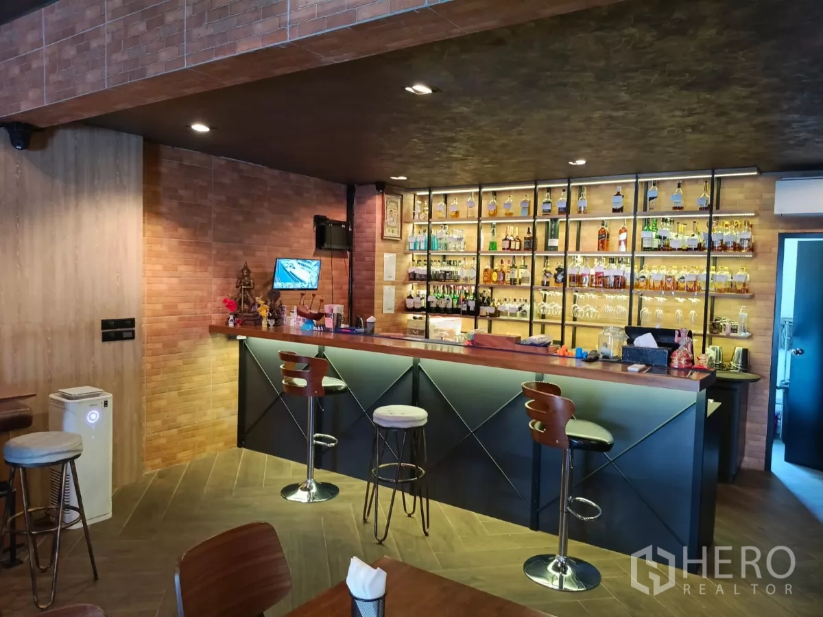Retail Space for rent - Angled view of stylish bar with backlit shelves and warm brick finishes.