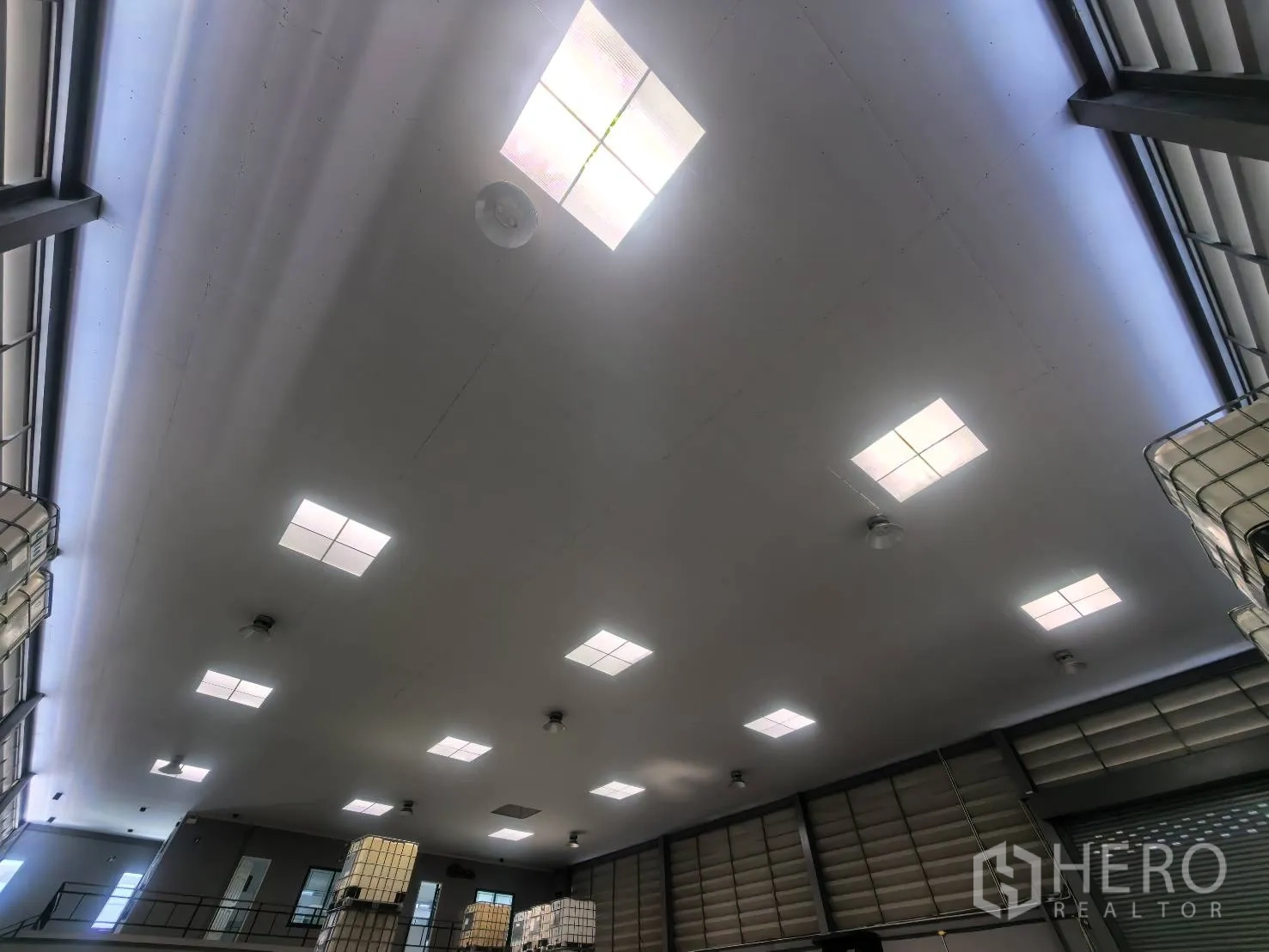 Warehouse for rent in Bang Sao Thong, Samut Prakan - Ceiling view showing square light panels and ventilation fans.