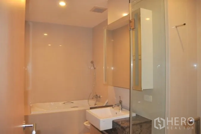 คอนโด ให้เช่าหรือขายในWatthana, Bangkok - ห้องน้ำสมัยใหม่พร้อมอ่างอาบน้ำ ฉากกั้นอาบน้ำกระจก และเคาน์เตอร์ล้างหน้า