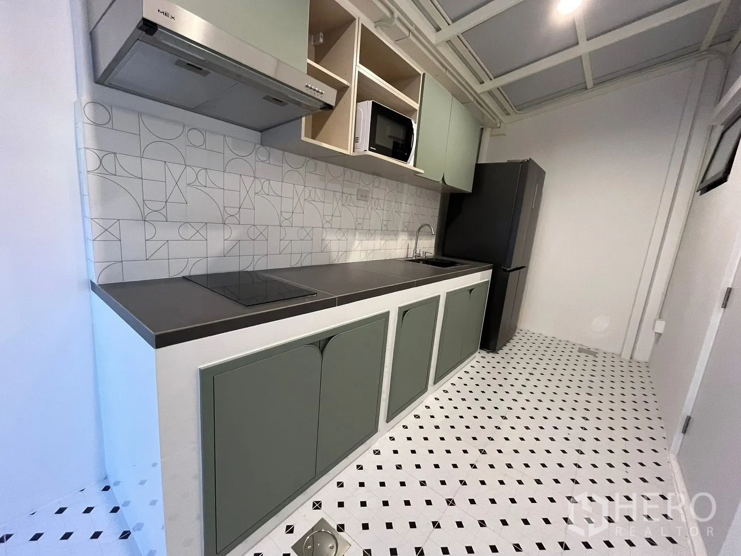 联排别墅 出租在Bang Phli, Samut Prakan - 内置厨房，薄荷绿柜体，几何瓷砖墙，感应炉、抽油烟机与冰箱。