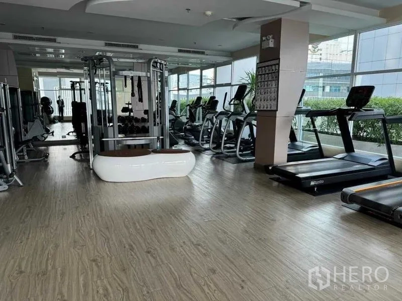 公寓 出售在Ratchathewi, Bangkok - 健身房配跑步机、力量训练器械与落地窗。