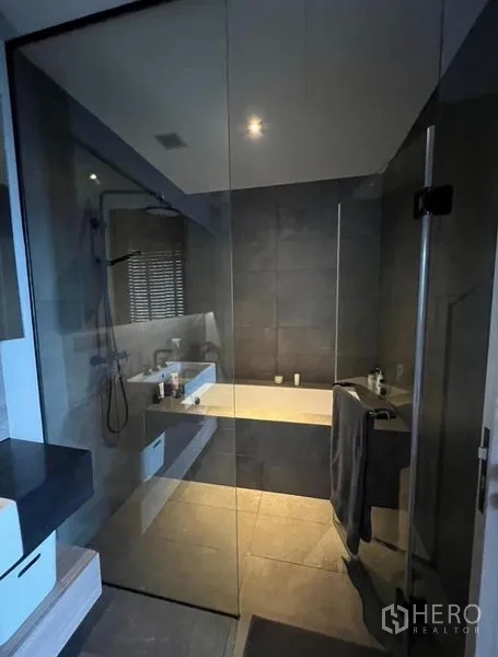 Condominium for rent in Watthana, Bangkok - Contemporary bathroom with glass shower enclosure and bathtub.