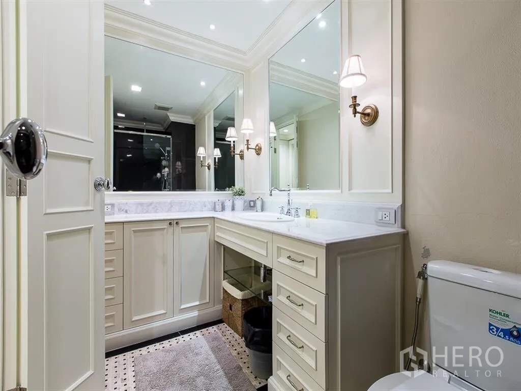 คอนโด ให้เช่าหรือขายในWatthana, Bangkok - ห้องน้ำสว่างพร้อมเคาน์เตอร์หินอ่อน กระจกบานใหญ่ และโคมไฟติดผนังสไตล์คลาสสิก