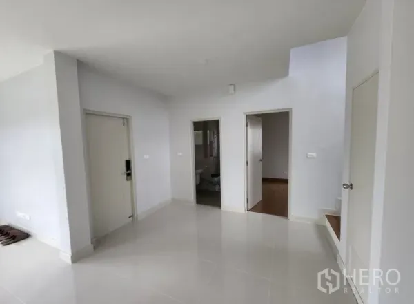 Detached House for rent in Bang Phli, Samut Prakan - Ground-floor foyer and living area with white tile floors, bathroom access and stairs.