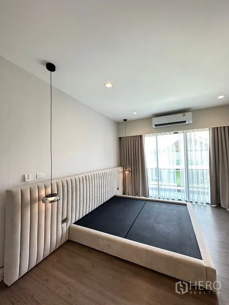 Detached House for rent or sale - Minimal master bedroom with upholstered headboard, pendant lights and balcony doors.
