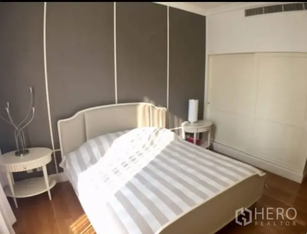 คอนโด ให้เช่าในWatthana, Bangkok - ห้องนอนมาสเตอร์รับแสงดี เตียงลายทาง ผนังเน้นสีเทา และตู้เสื้อผ้าบิลท์อิน