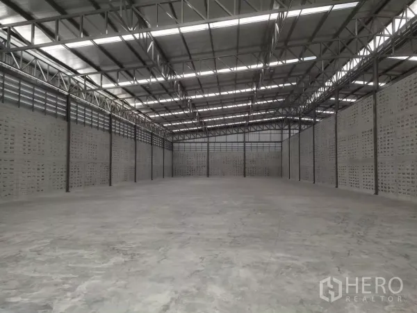 Warehouse for rent in Samut Prakan - Expansive warehouse interior featuring high steel truss roof, skylights and polished concrete floor.
