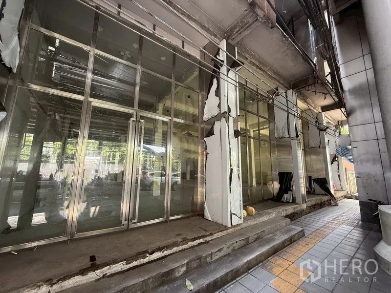 อาคารพาณิชย์ ให้เช่า - ด้านหน้าอาคารพาณิชย์กระจกบานใหญ่พร้อมกรอบโลหะและขั้นบันได ในบางจาก พระโขนง