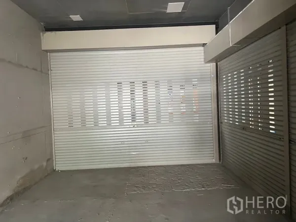 พื้นที่ขายปลีก ให้เช่าในKhlong Toei, Bangkok - พื้นที่ร้านค้าว่างพร้อมประตูม้วนโลหะสองด้านและพื้นคอนกรีตยังไม่ปู