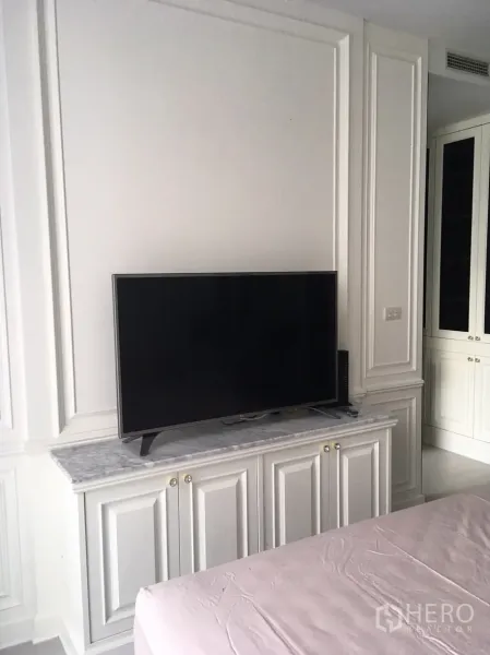 คอนโด ให้เช่าในPathum Wan, Bangkok - ผนังทีวีในห้องนอน วางทีวีจอแบนบนตู้ท็อปหินอ่อนพร้อมตู้บิลท์อิน