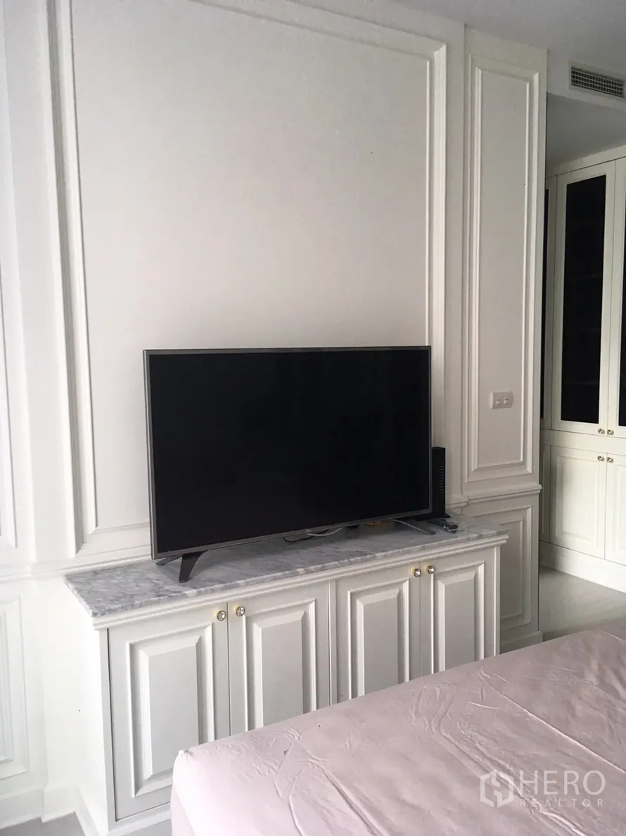 คอนโด ให้เช่าในPathum Wan, Bangkok - ผนังทีวีในห้องนอน วางทีวีจอแบนบนตู้ท็อปหินอ่อนพร้อมตู้บิลท์อิน