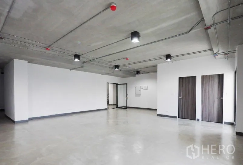 Office Space for rent in Khlong Toei, Bangkok - Open-plan 87 sqm office in Thonglor, Bangkok with polished concrete floor, exposed ceiling lighting, glass entry and two wooden doors.