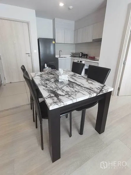 Condominium for rent in Pathum Wan, Bangkok - Dining area featuring a marble-top table and four black chairs.