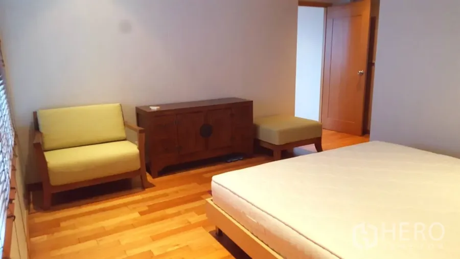 公寓 出租或出售在Khlong Toei, Bangkok - 温馨卧室，木地板，小沙发、木柜与床架。